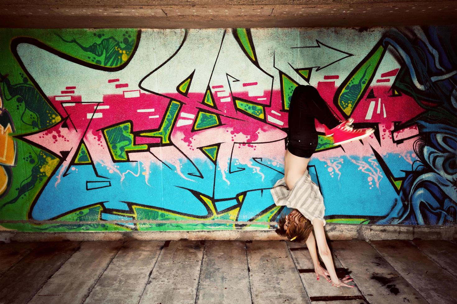 polonia, 2022 - chica elegante en una pose de baile contra la pared de graffiti foto