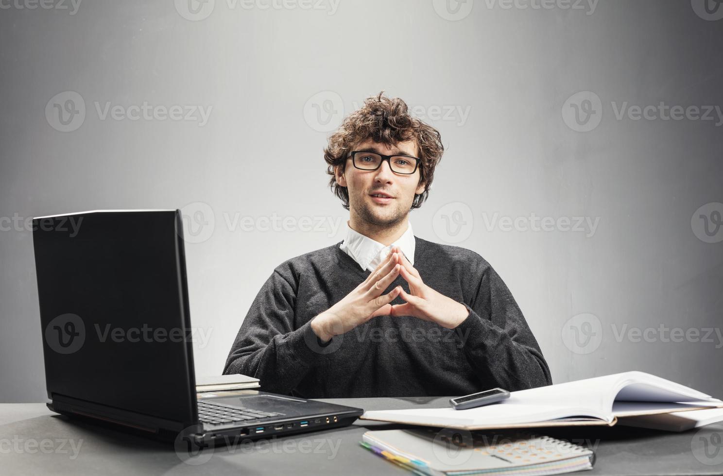Young serious man sitting in his workplace photo