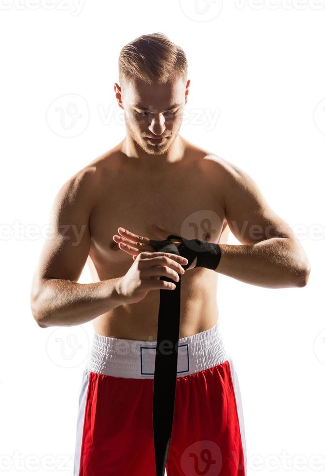 Fighter wrapping his hands with elastic band. photo