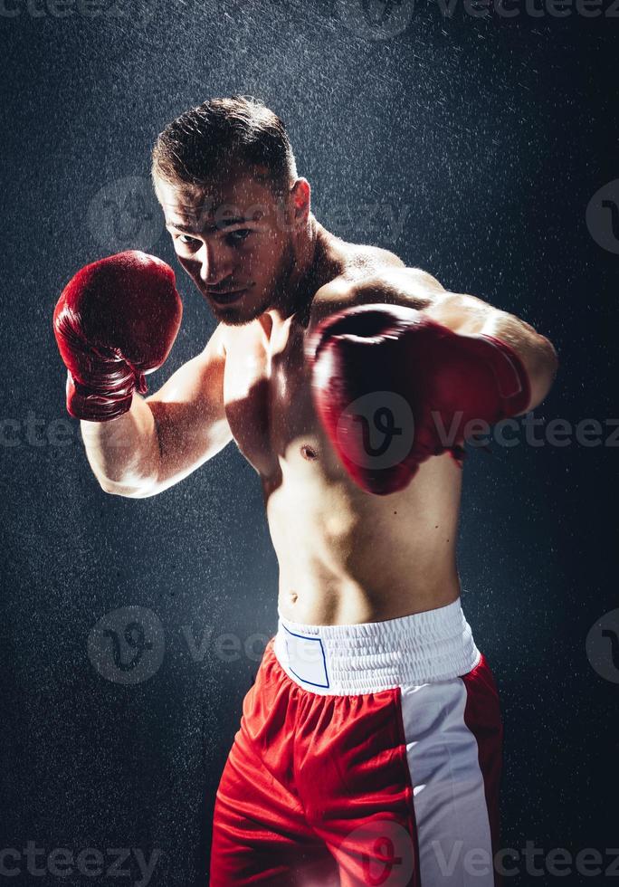 Boxing man ready to fight in the rain. photo