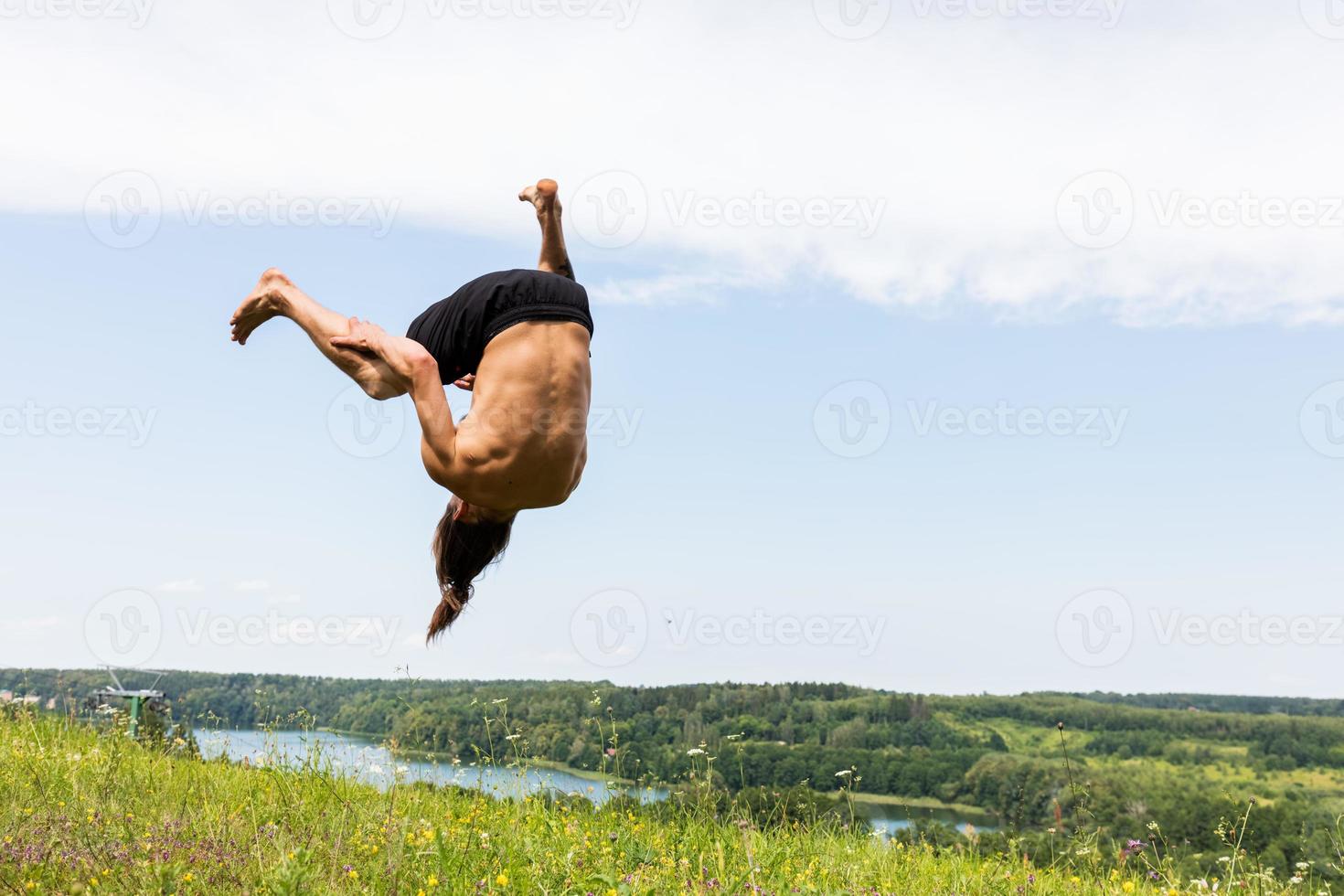 Young man jumping on a hill. photo