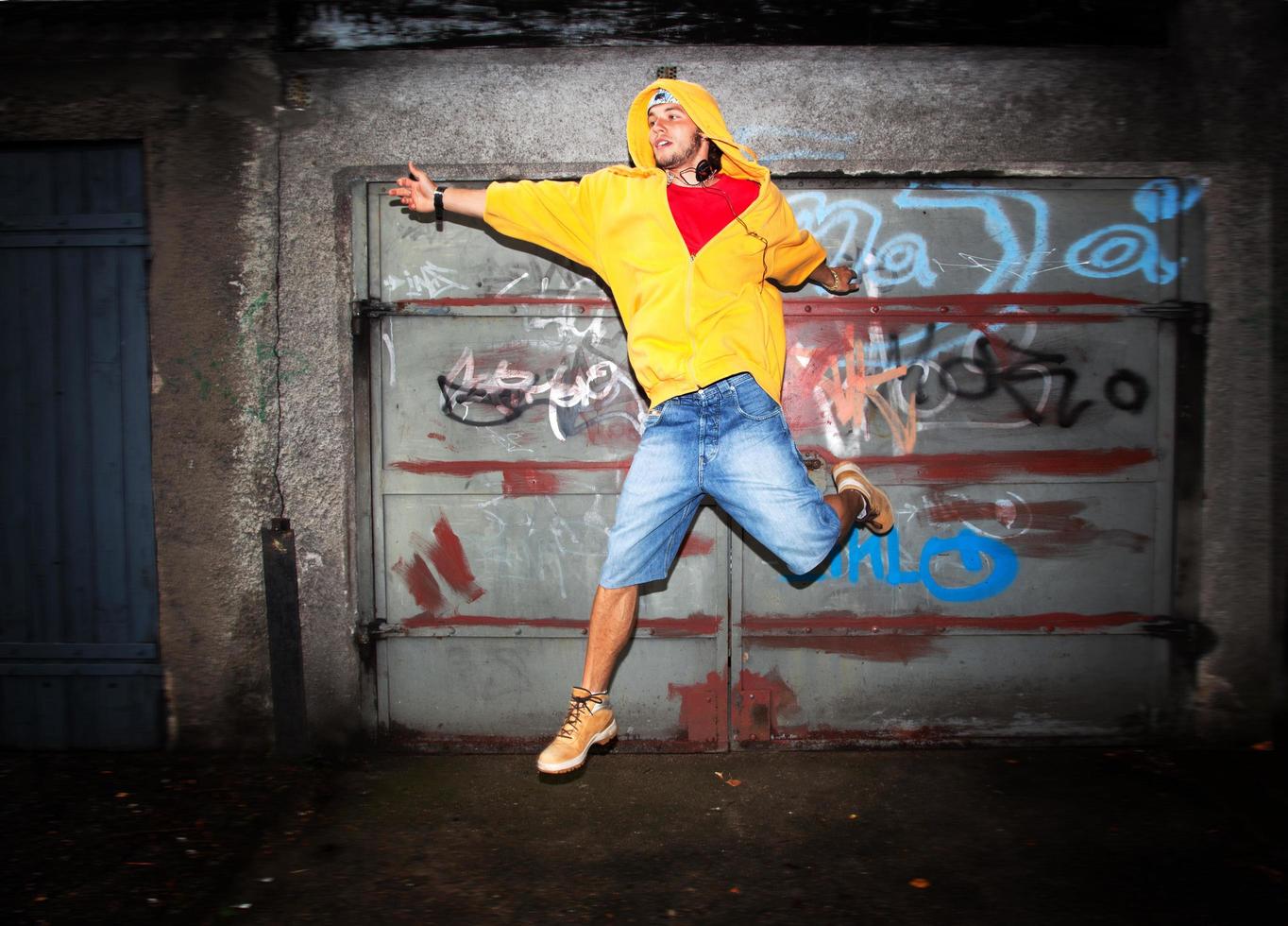 Poland, 2022 - Young man jumping on grunge wall photo