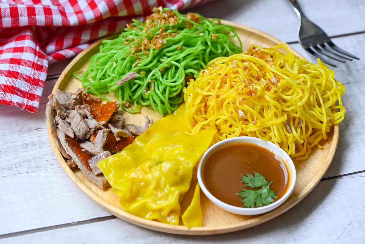 Jade noodle and yellow noodles Asian Thailand food , roasted duck with jade noodle and pork dumplings on plate and duck sauce , green noodles Chinese food photo