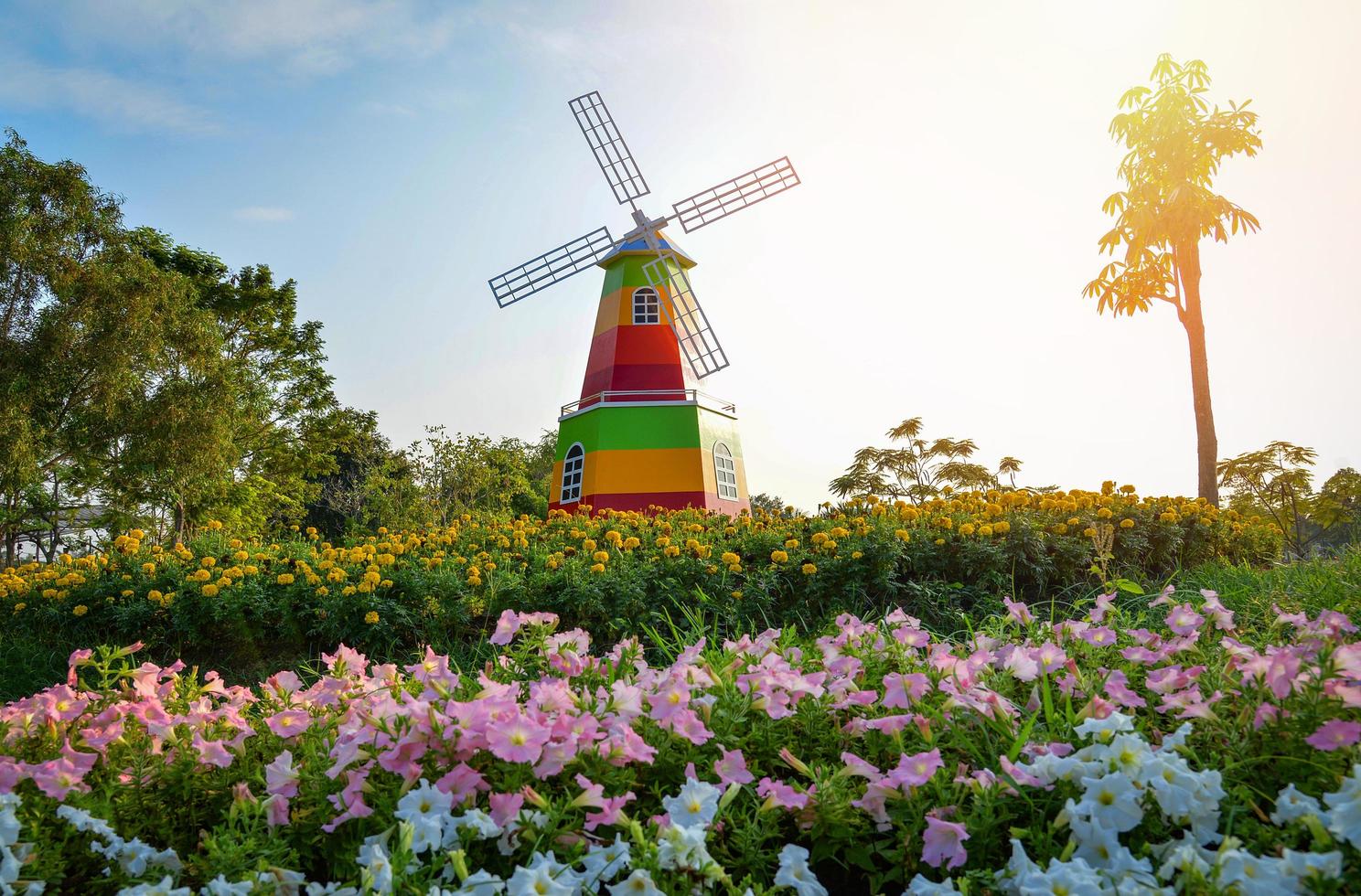 paisaje colorido jardín de flores y molino de viento en la naturaleza de la colina en el parque del jardín foto