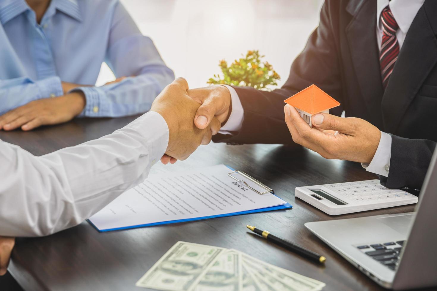 Real estate agents shaking hands To congratulate buyers after giving buyers a purchase contract, a contract idea. Trading houses and real estate. photo