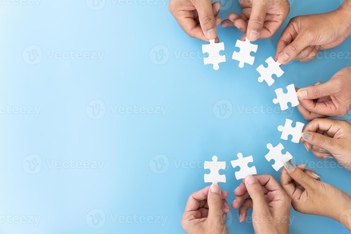 A group of business people assembling jigsaw puzzle.  Successful teamwork in finding business solutions.The concept of cooperation,  help and support in business. photo