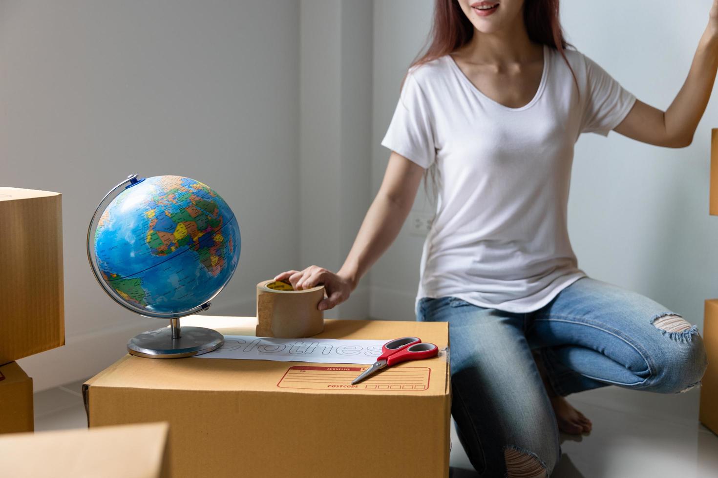 An Asian woman checks items before packing them in cardboard to move out of her apartment. photo