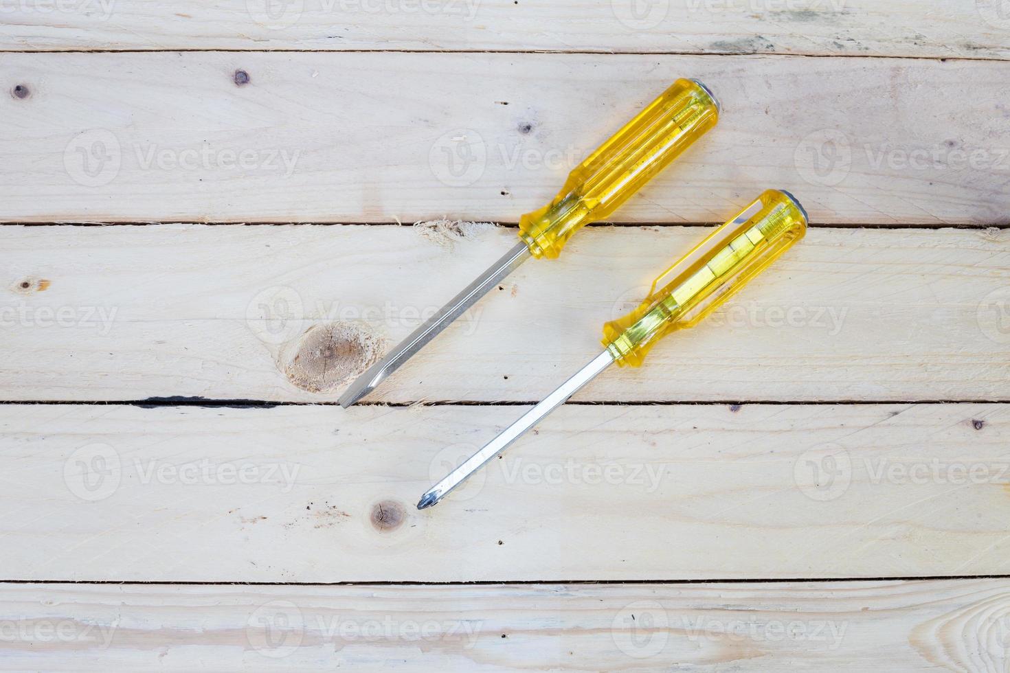 Screw drivers on white wooden background photo