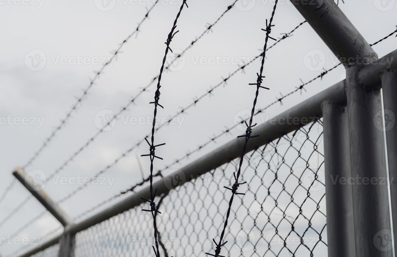 Prison security fence. Border fence. Barbed wire security fence. Razor wire jail fence. Boundary security wall. Prison for arrest of criminals or terrorists. Private area. Military zone concept. photo