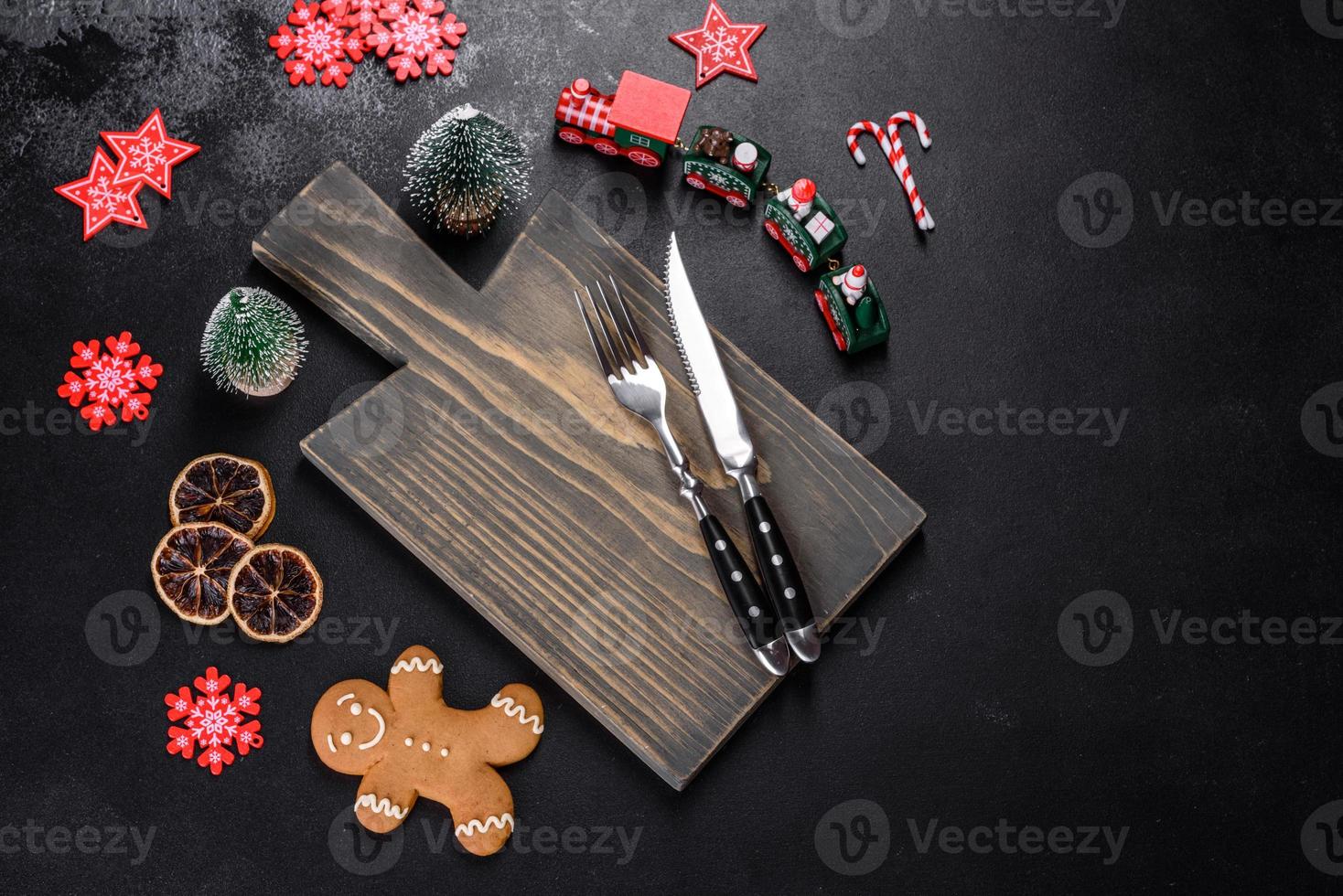 Christmas homemade gingerbread cookies, spices and cutting board on dark background photo