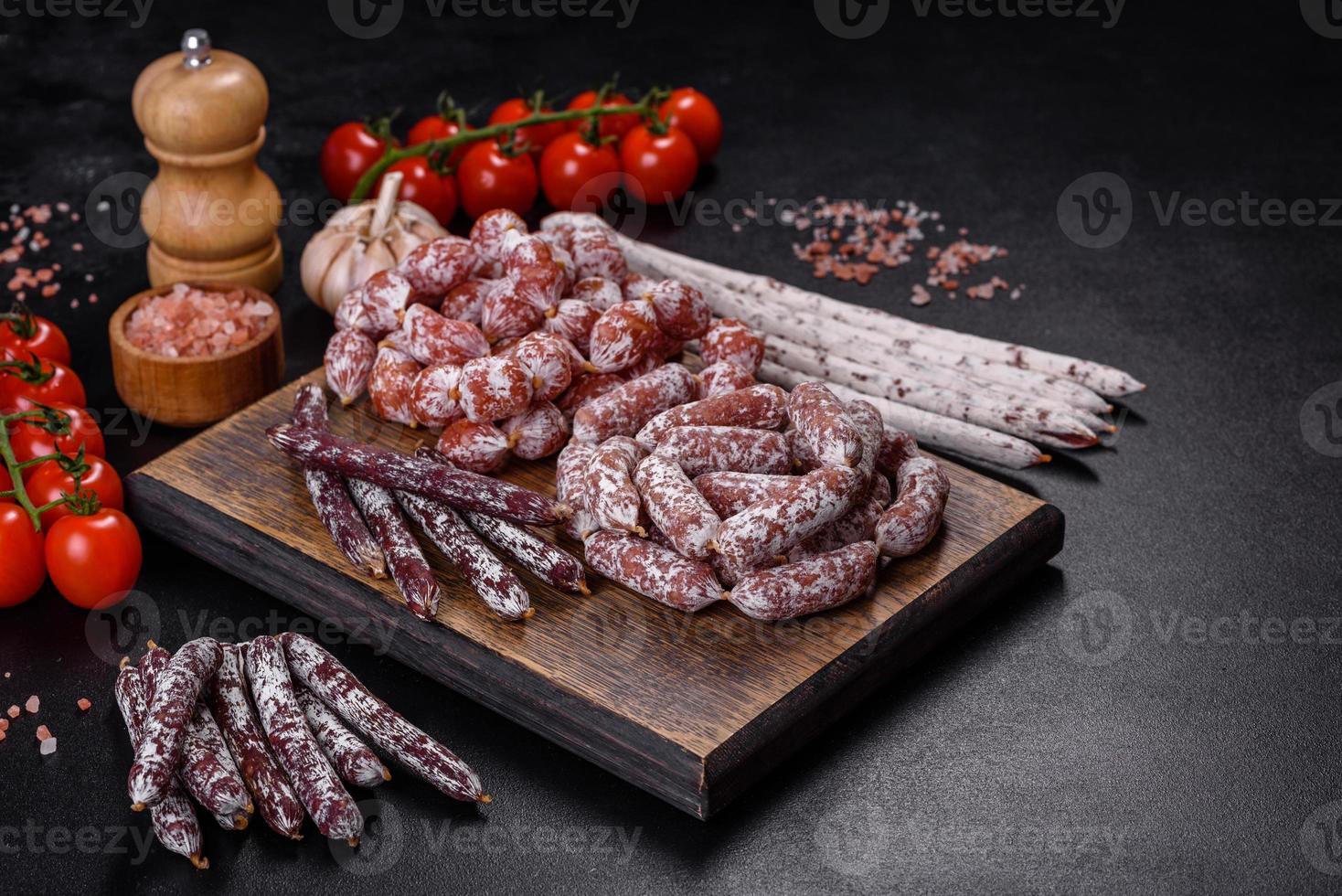 Delicious dry sausage with walnuts on a concrete table. Dry cured fuet