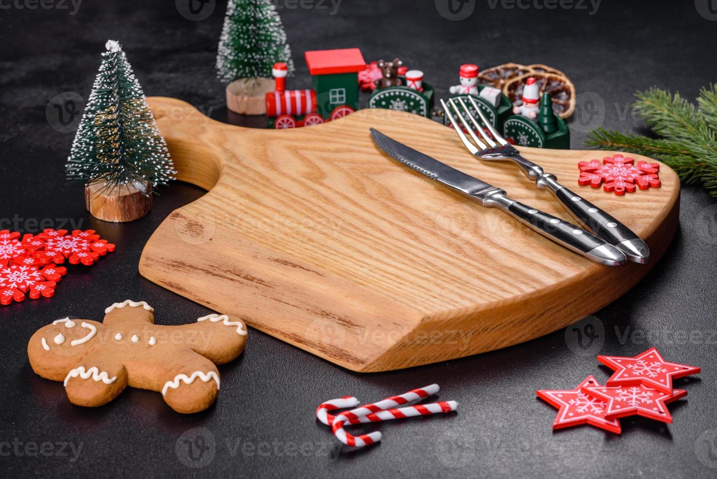Christmas homemade gingerbread cookies, spices and cutting board on dark background photo