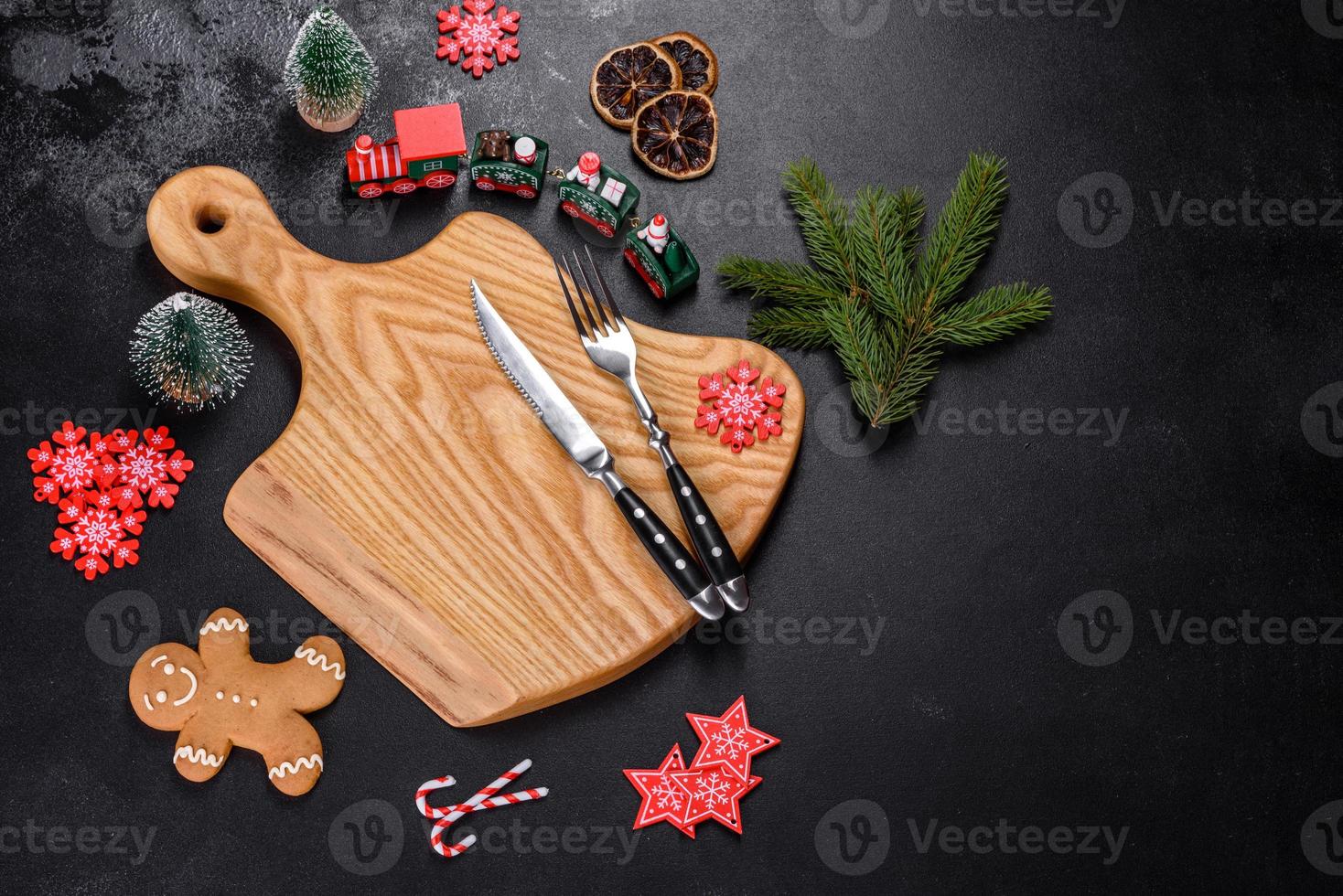 Christmas homemade gingerbread cookies, spices and cutting board on dark background photo