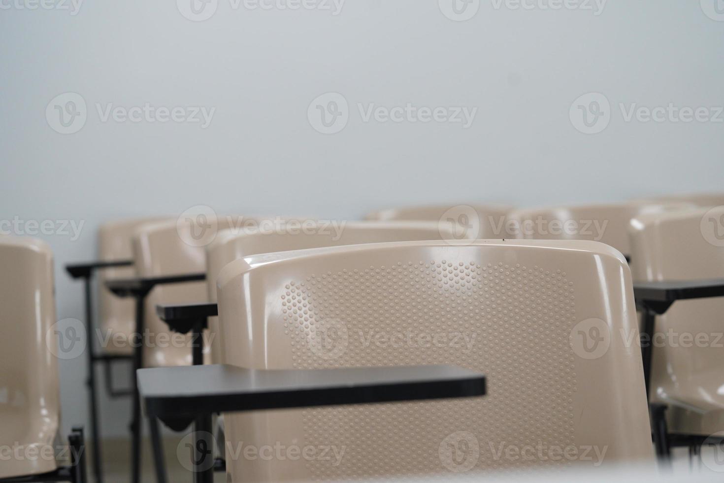 Empty class at university or school with chairs and side table, the chairs are arranged in rows. photo