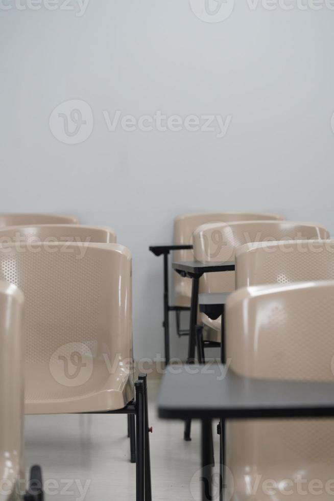 Empty class at university or school with chairs and side table, the chairs are arranged in rows. photo