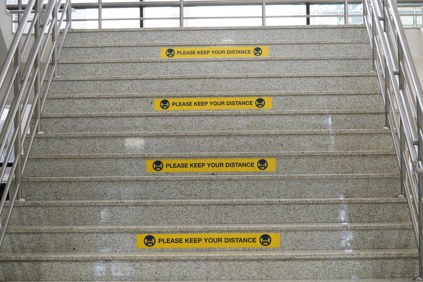 mantenga su etiqueta de distancia en las escaleras o el edificio de la universidad. etiqueta de distancia real. etiquetas amarillas rectangulares. foto