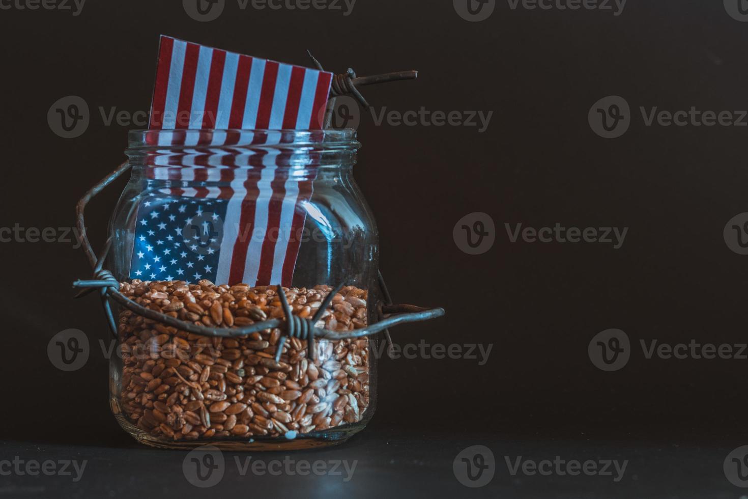 Wheat grain in a jar around barbed wire, the concept of sanctions and the crisis in USA, Problems with USA grain, the blockade of USA grain. photo