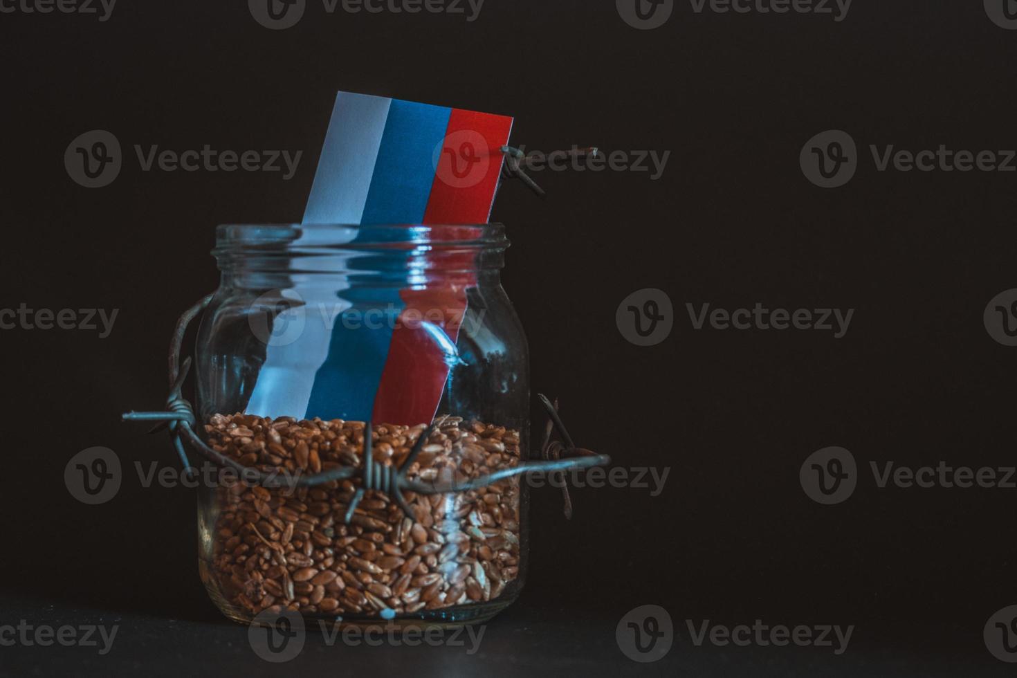 Wheat grain in a jar around barbed wire, the concept of sanctions and the crisis in Russia, Problems with Russia grain, the blockade of Russia grain. photo