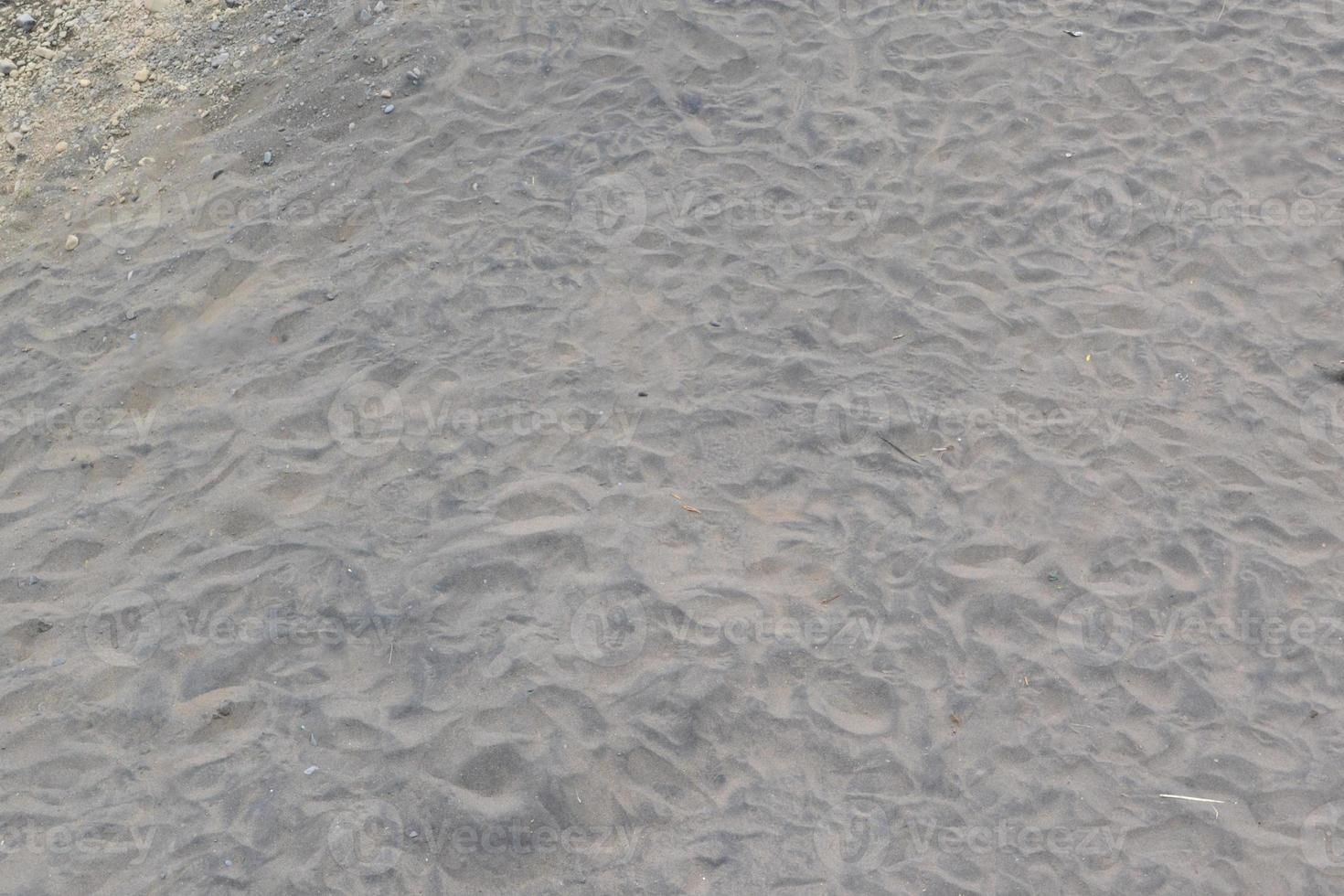 pattern of brown river sand with trail marks of water wave photo