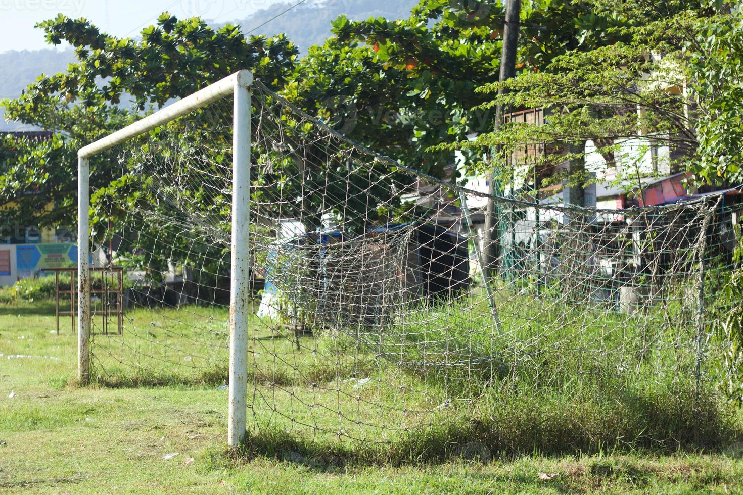 Football or soccer goal net at old grass field. photo