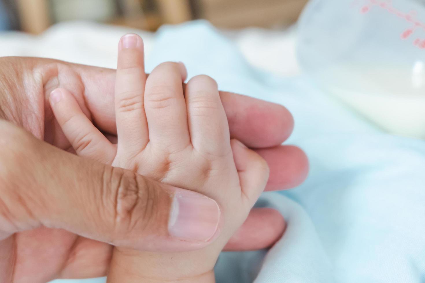 father holding baby's hand photo