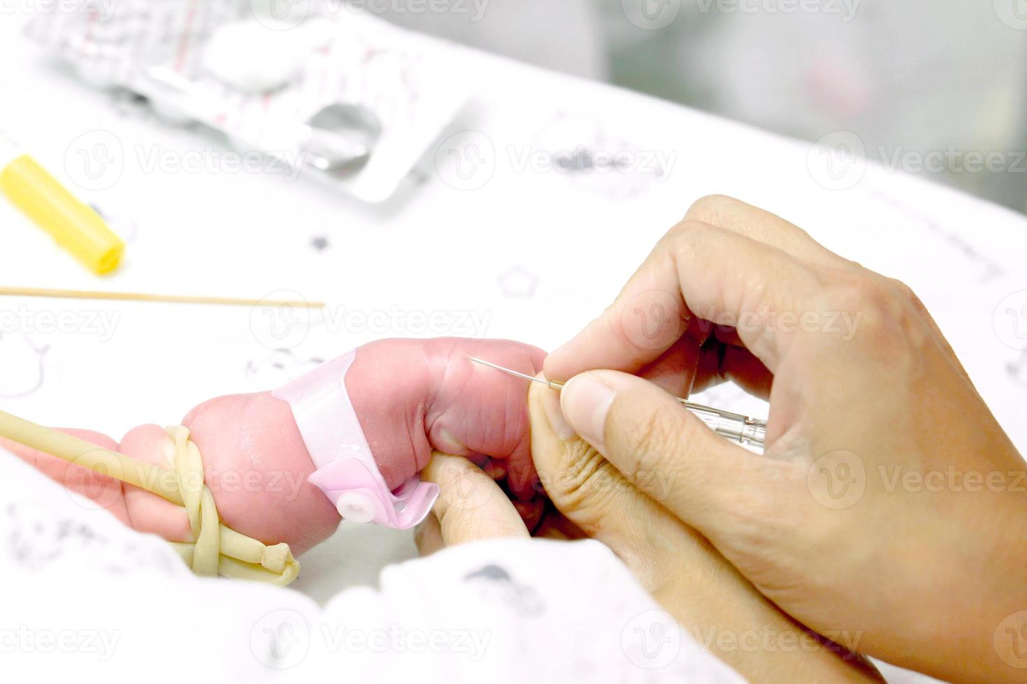 Image of nurse hands uses gradually stabbing IV Catheter at sick baby's hands to prepare fill the saline solution and medicine. photo