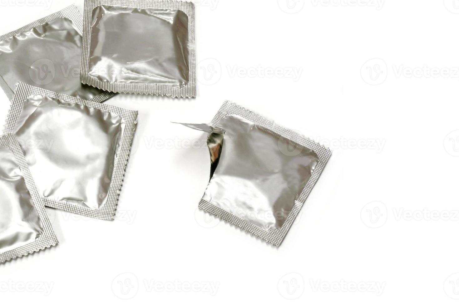 Condom in seal package and opened isolate on white background. photo