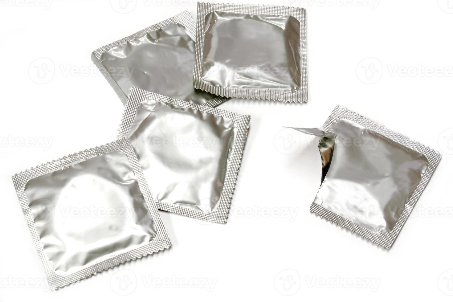 Condom in seal package and opened isolate on white background. photo