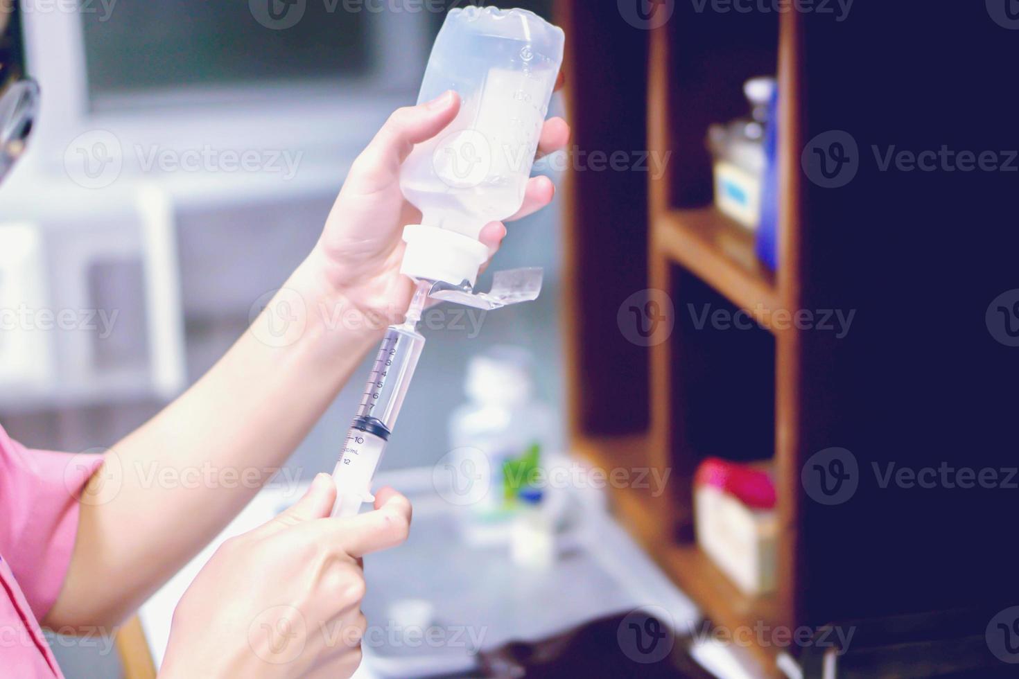 A picture of nurse hands in preparation an injection vaccine for the patient in blue light tone. photo