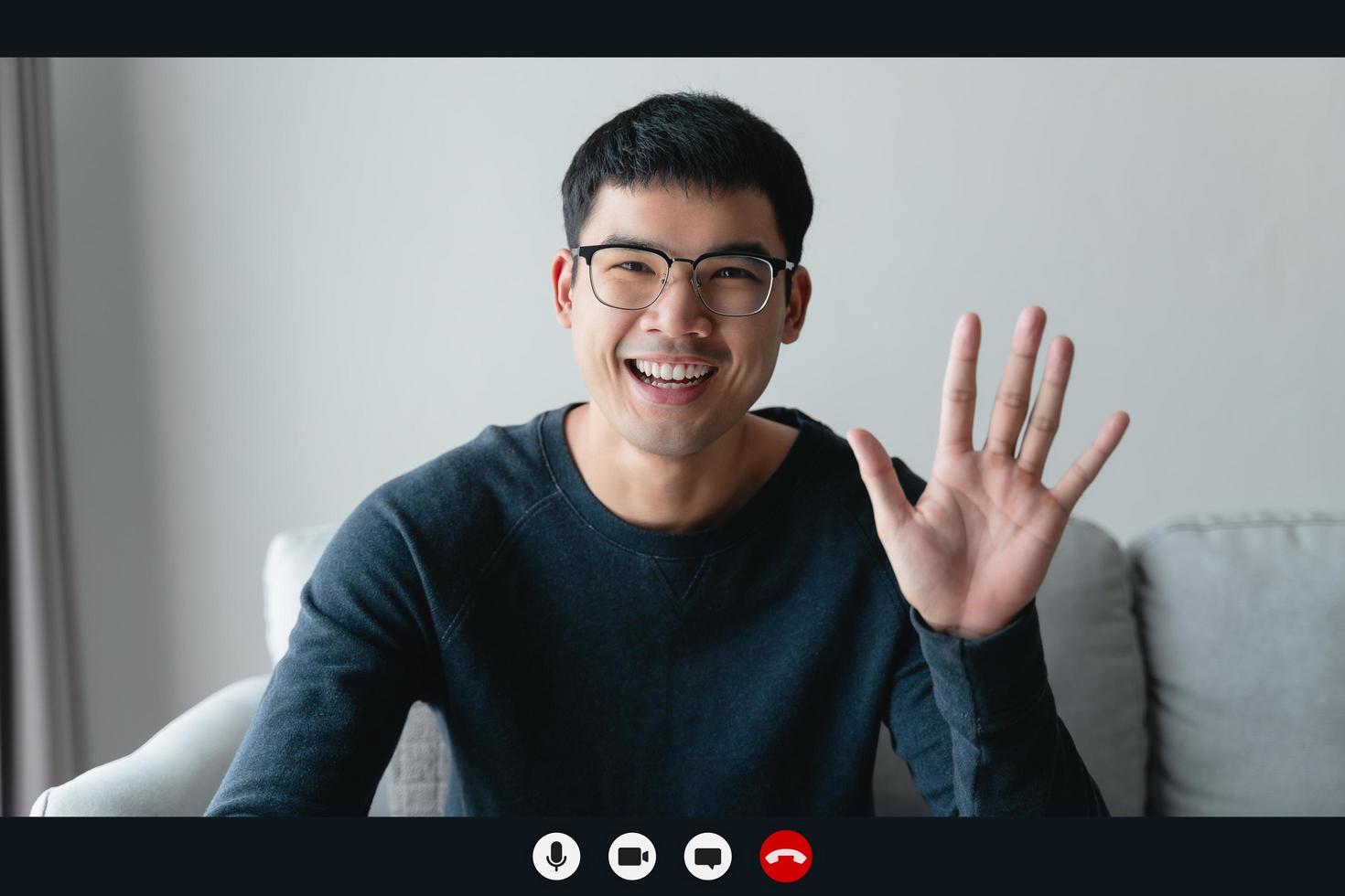 retrata a un hombre feliz trabajando en casa por videoconferencia reuniéndose agitando la mano, hablando y mirando la cámara. saludar a familiares o amigos foto