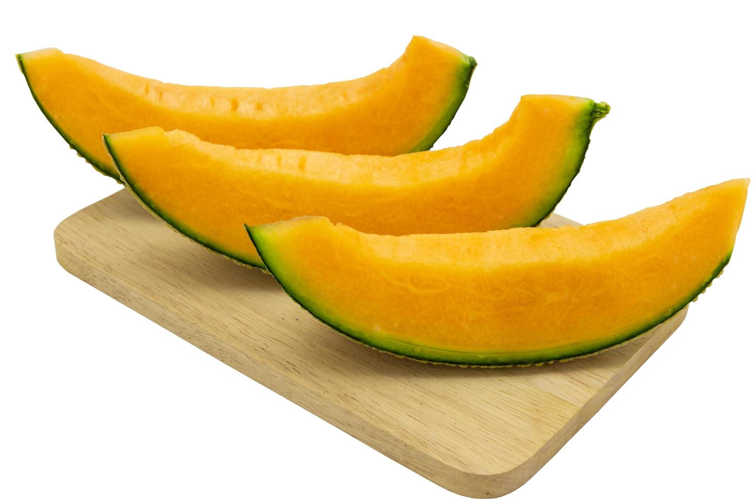 Closeup melon bright colors that is pieces on wooden tray isolated on white background. clipping path photo