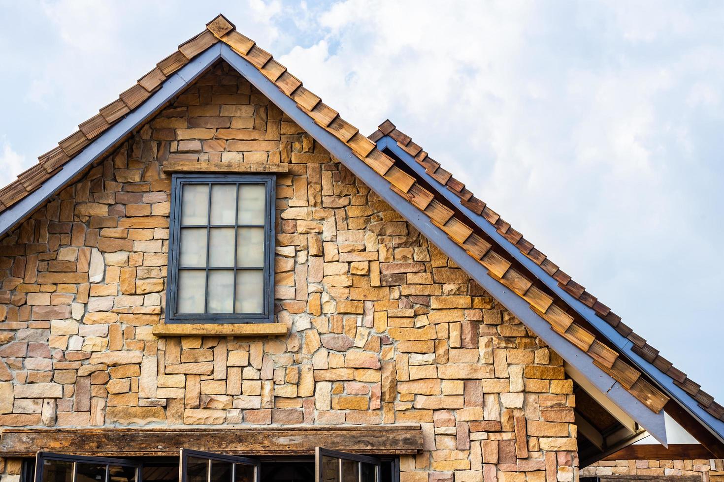 Classic roof decorated with stone and wood in vintage style. Traditional building photo