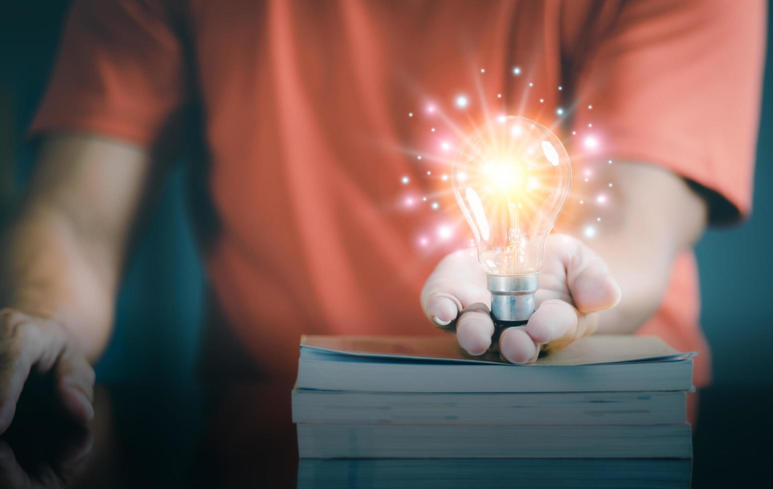 young businessman holding a light bulb in his hand photo