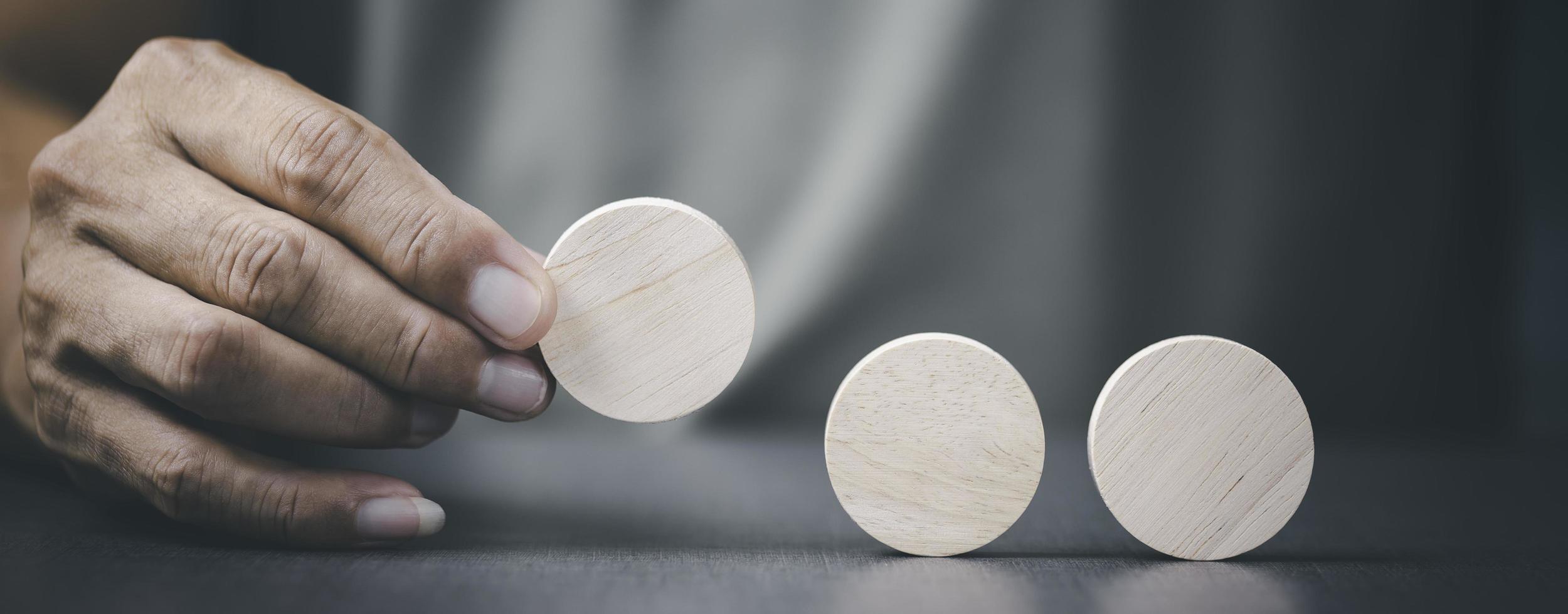 The young man had picked a wooden block that was placed on the table , photo