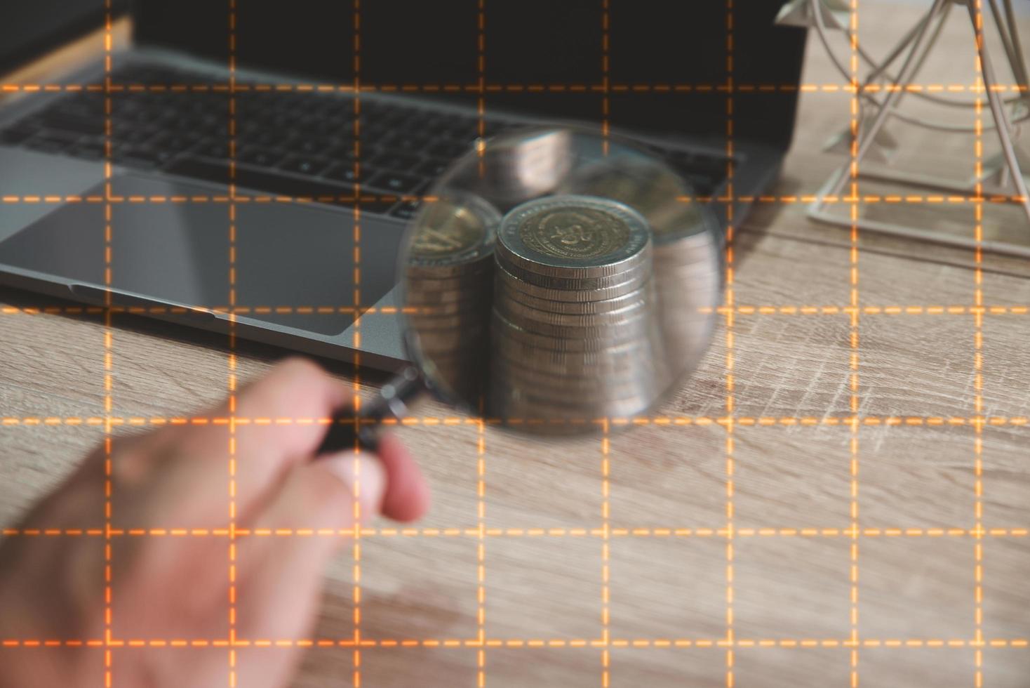 Hold a magnifying glass on a pile of coins photo