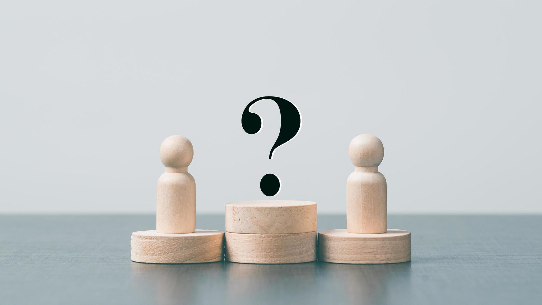 Wooden doll, wooden block and question mark icon. on the table photo