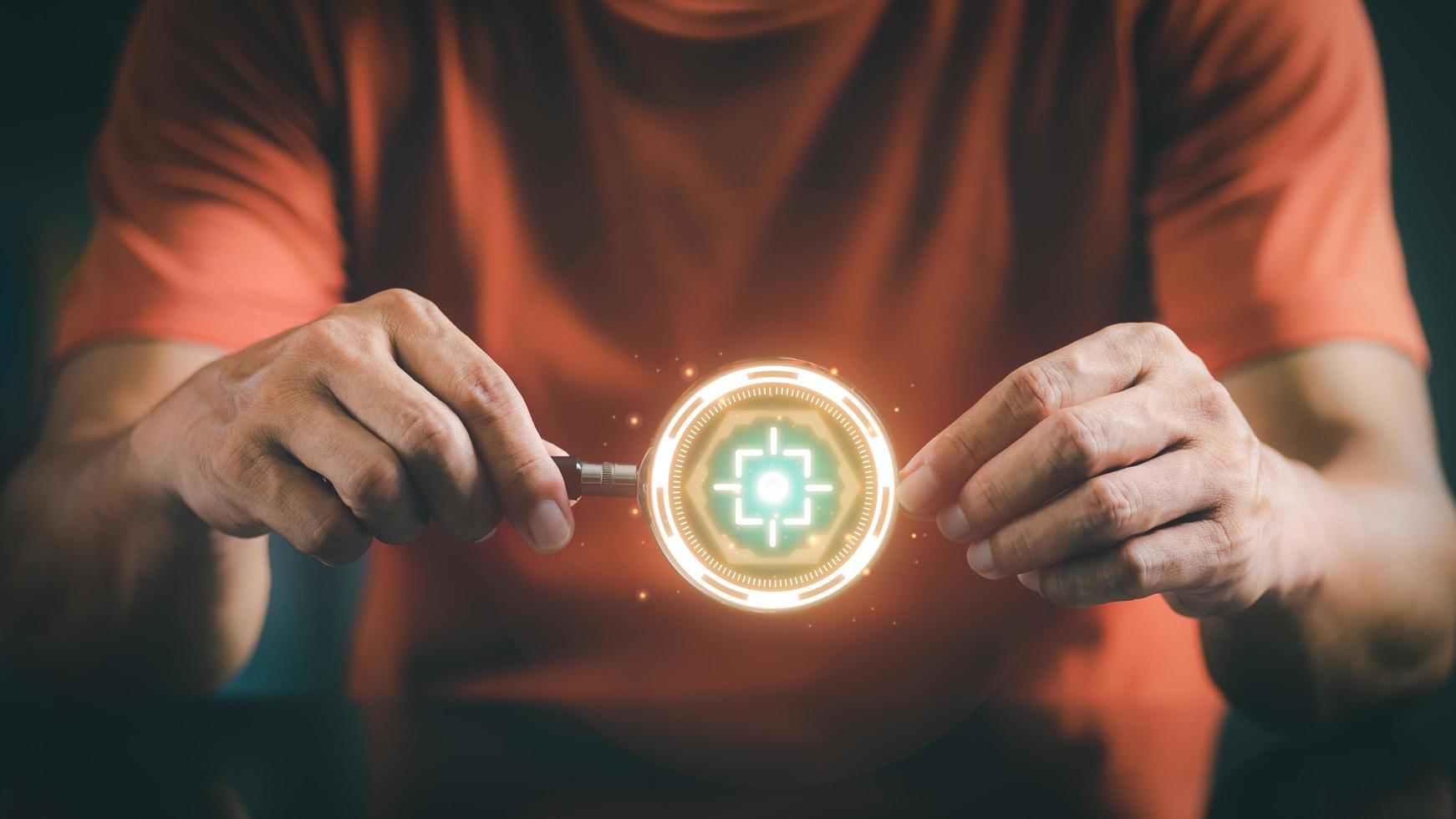 Hand of a young businessman holding a magnifying glass photo