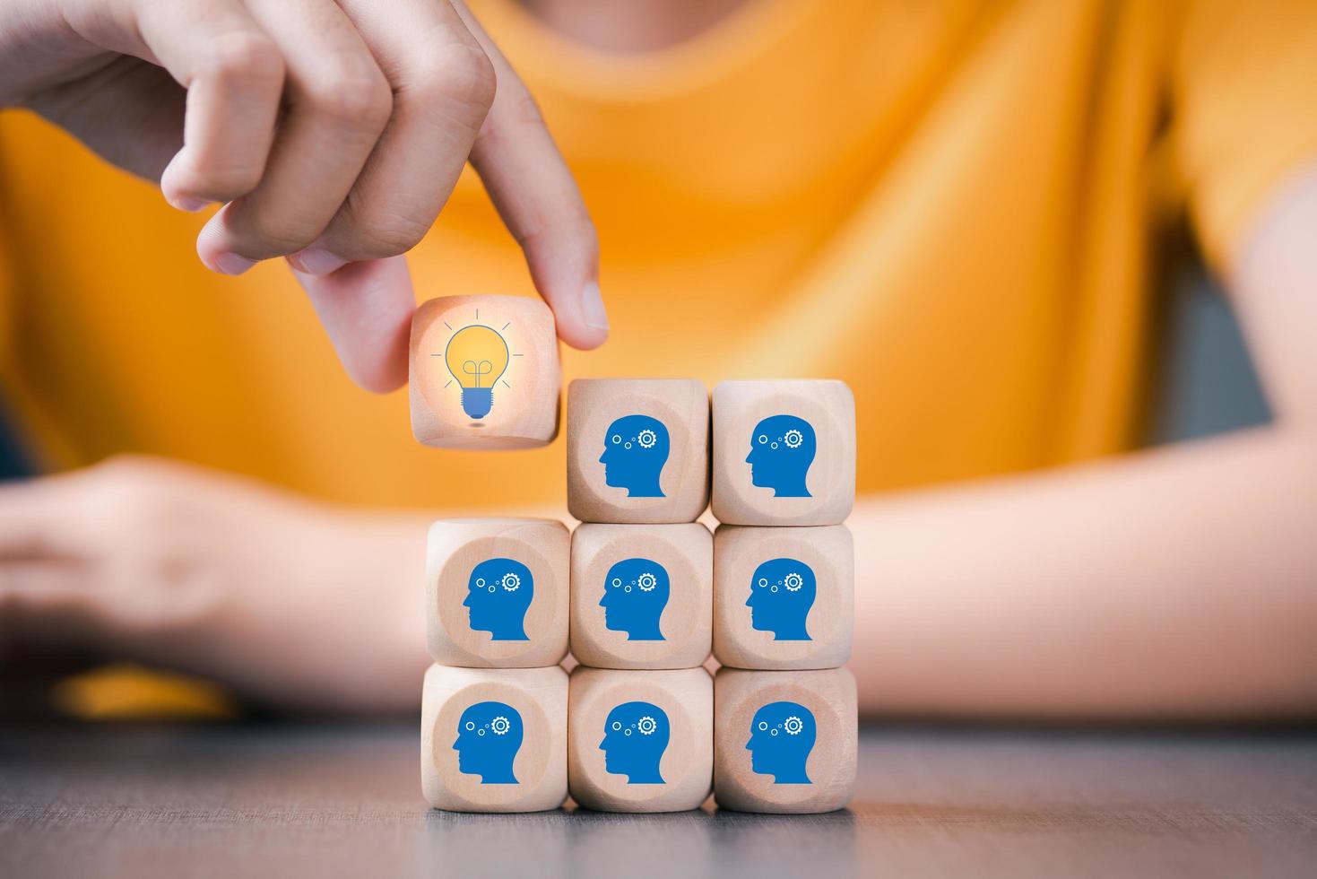 bloque de madera con ícono de bombilla en mano femenina, soluciones conceptuales creativas, con ideas e innovaciones de la invención que utiliza la inspiración de la imaginación que se ha desarrollado en nuevas tecnologías foto