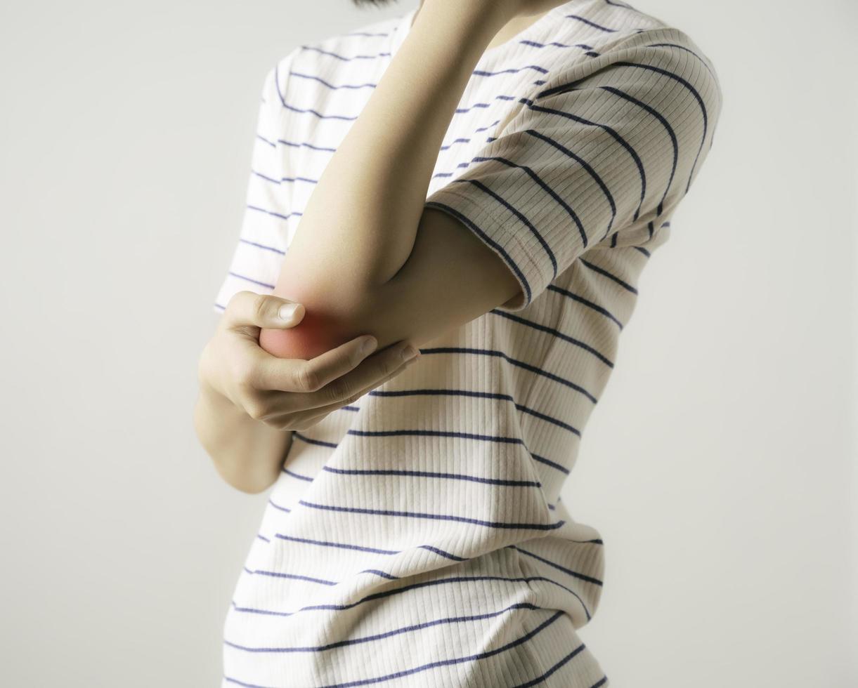 An Asian woman showing pain in her elbow. photo