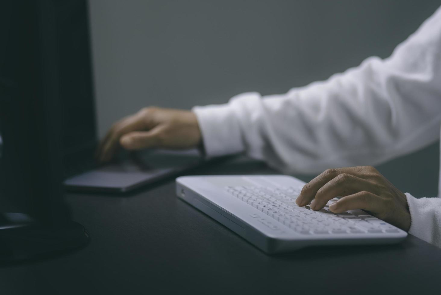 mujer joven que trabaja frente a la computadora en el escritorio foto