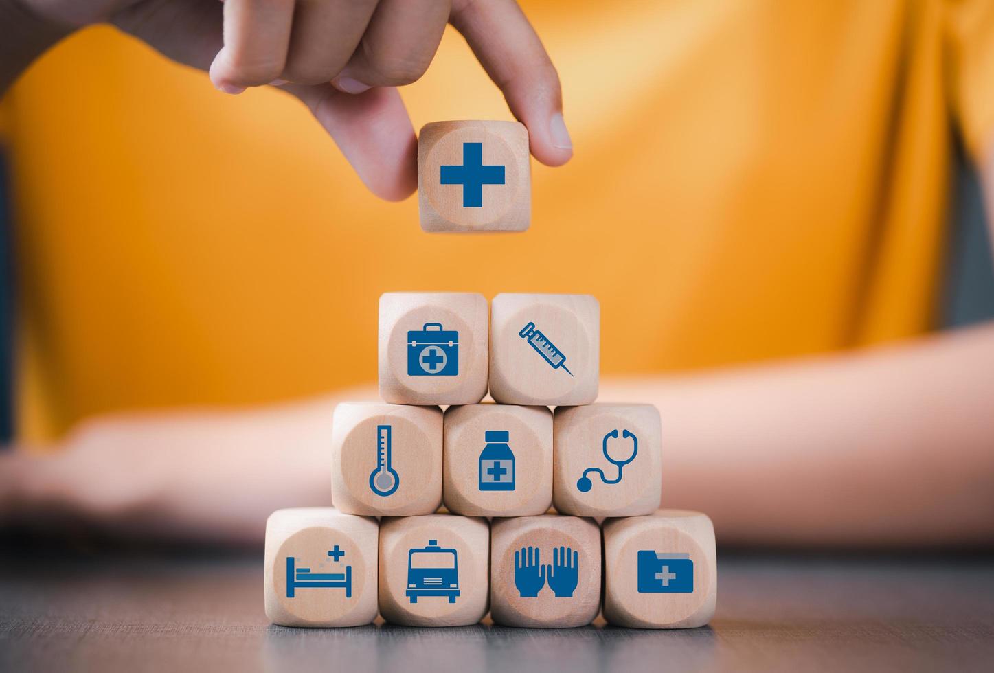 wooden block in woman's hand, health care concept Shown as icons such as stethoscope, syringe, ambulance, health care planning from doctors, hospitals for prevention, life safety is a good investment. photo