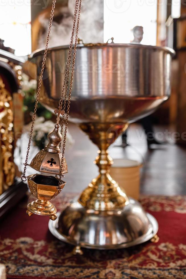 selective focus. A priest's censer hangs on an old wall in the Orthodox Church. Copper incense with burning coal inside. Service in the concept of the Orthodox Church. Adoration photo