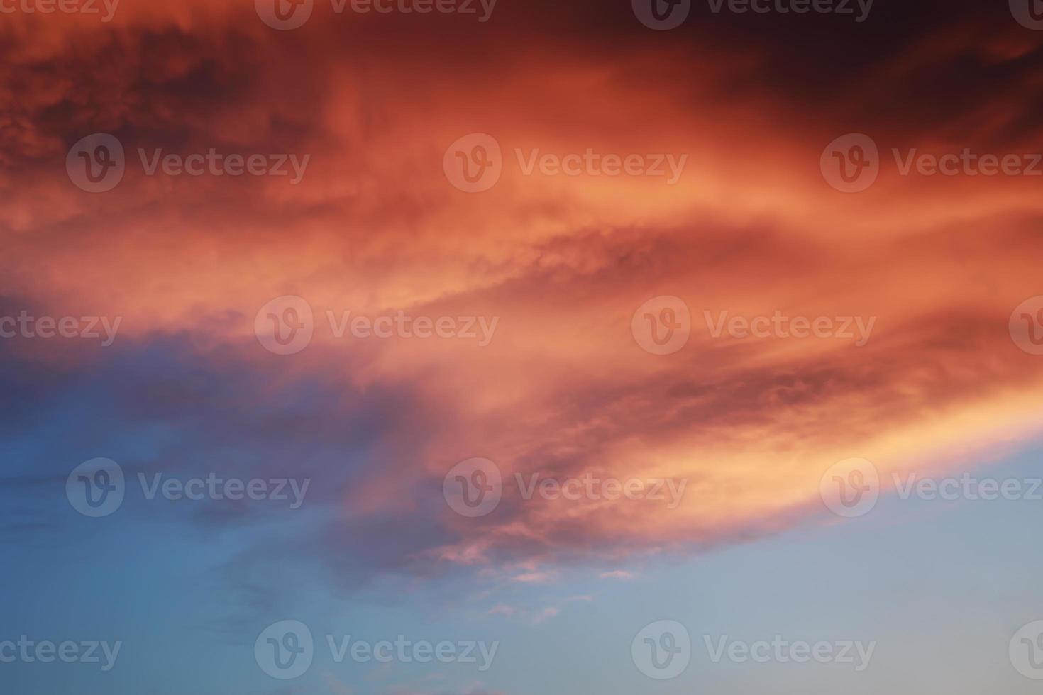 espectacular paisaje de puesta de sol con nubes hinchadas iluminadas por el sol naranja y el cielo azul. foto