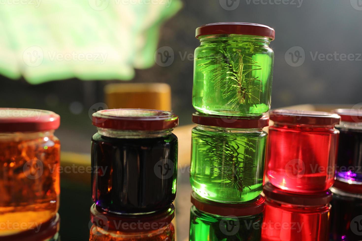 Many jars with honey tinctures of forest herbs, pine needles, flowers and Iceland moss. Means and medicines of folk medicine. alcoholic tincture of herbs. selective focus photo