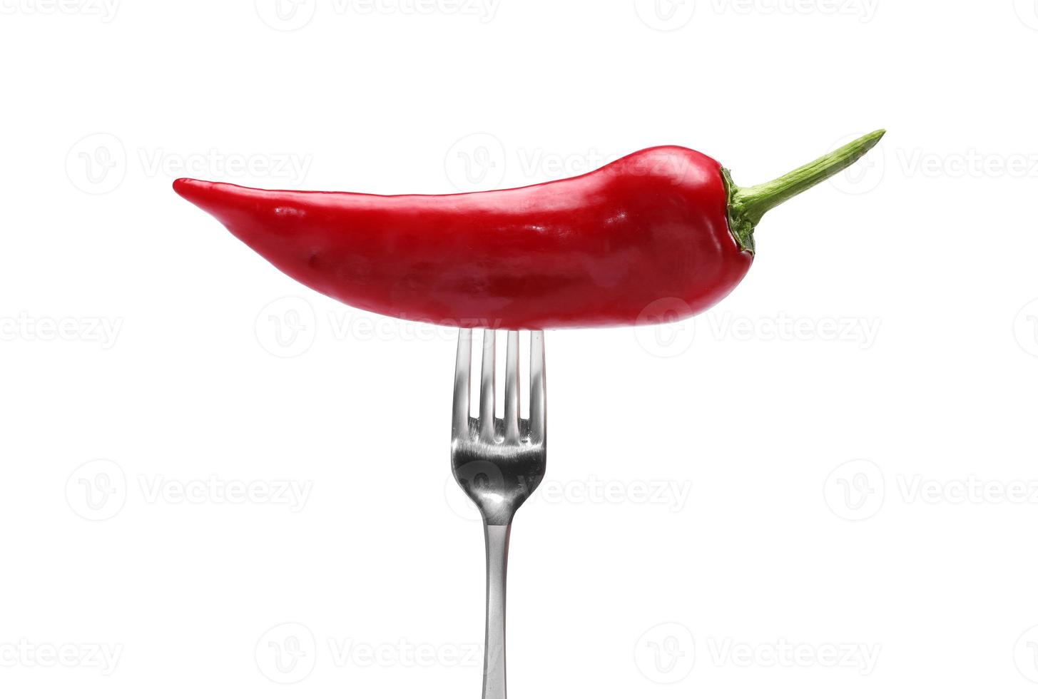 side view of red pepper on fork on white background. Domestic cultivation. Fresh vegetables. Vegetarian dinner. Paprika on a fork. Isolated from background photo
