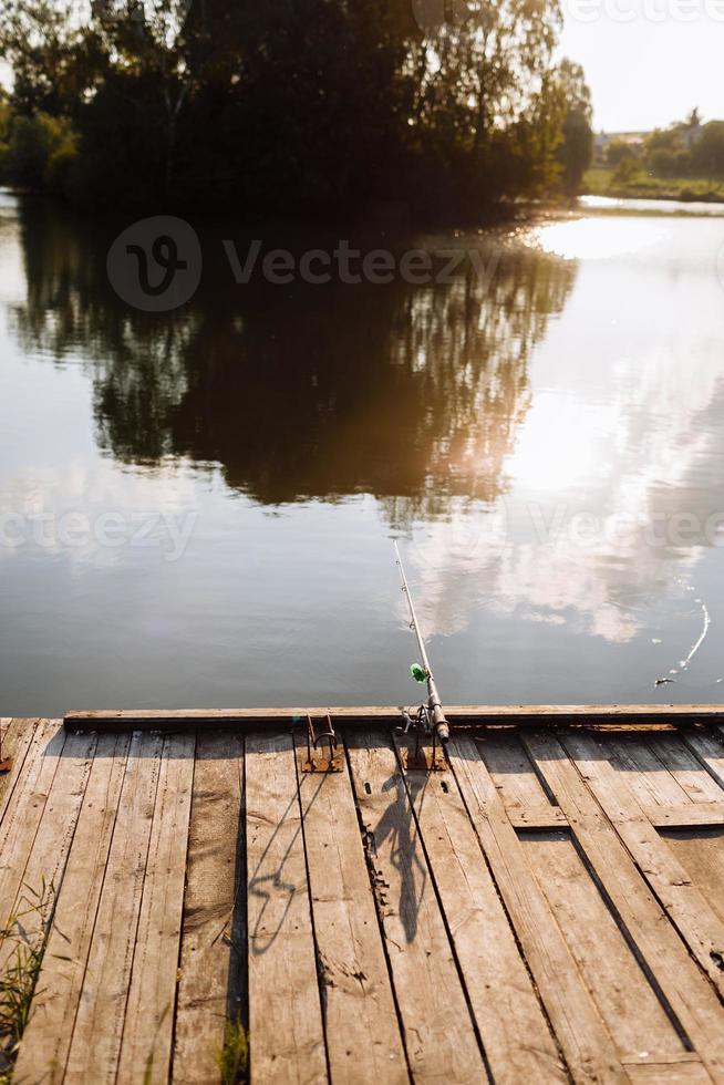 Fisherman with rod, spinning reel on the river bank. Fishing for