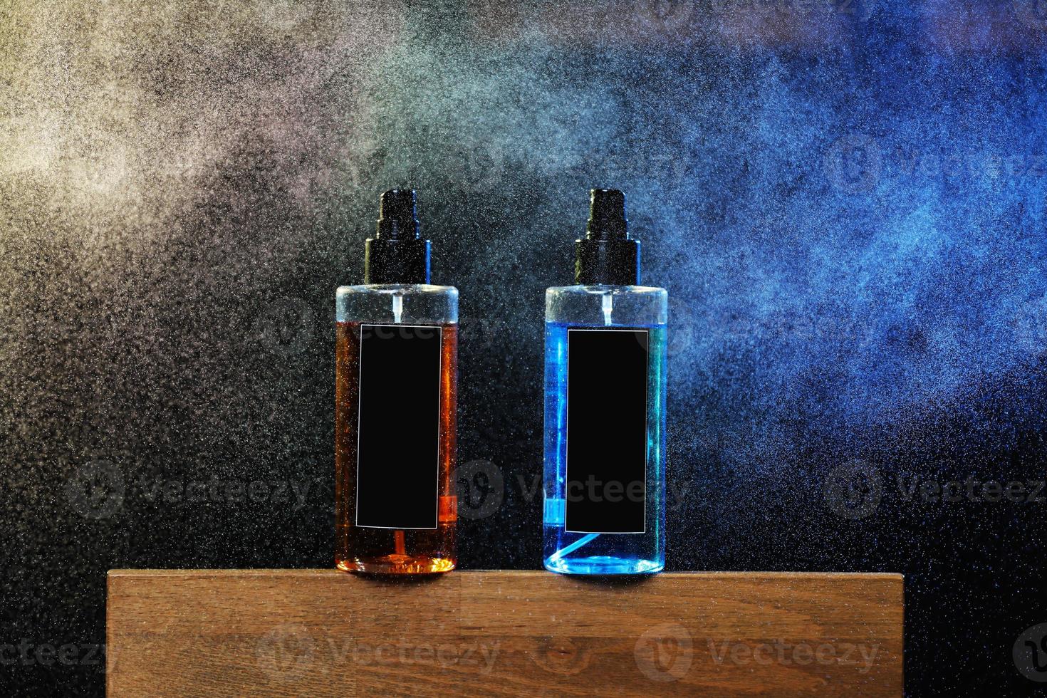 two bottles with yellow and blue liquid. two spray spraying cans on black background on wooden stand. mockup on cans, jars. selective focus. barbershop. tool for hairstyles and beards photo