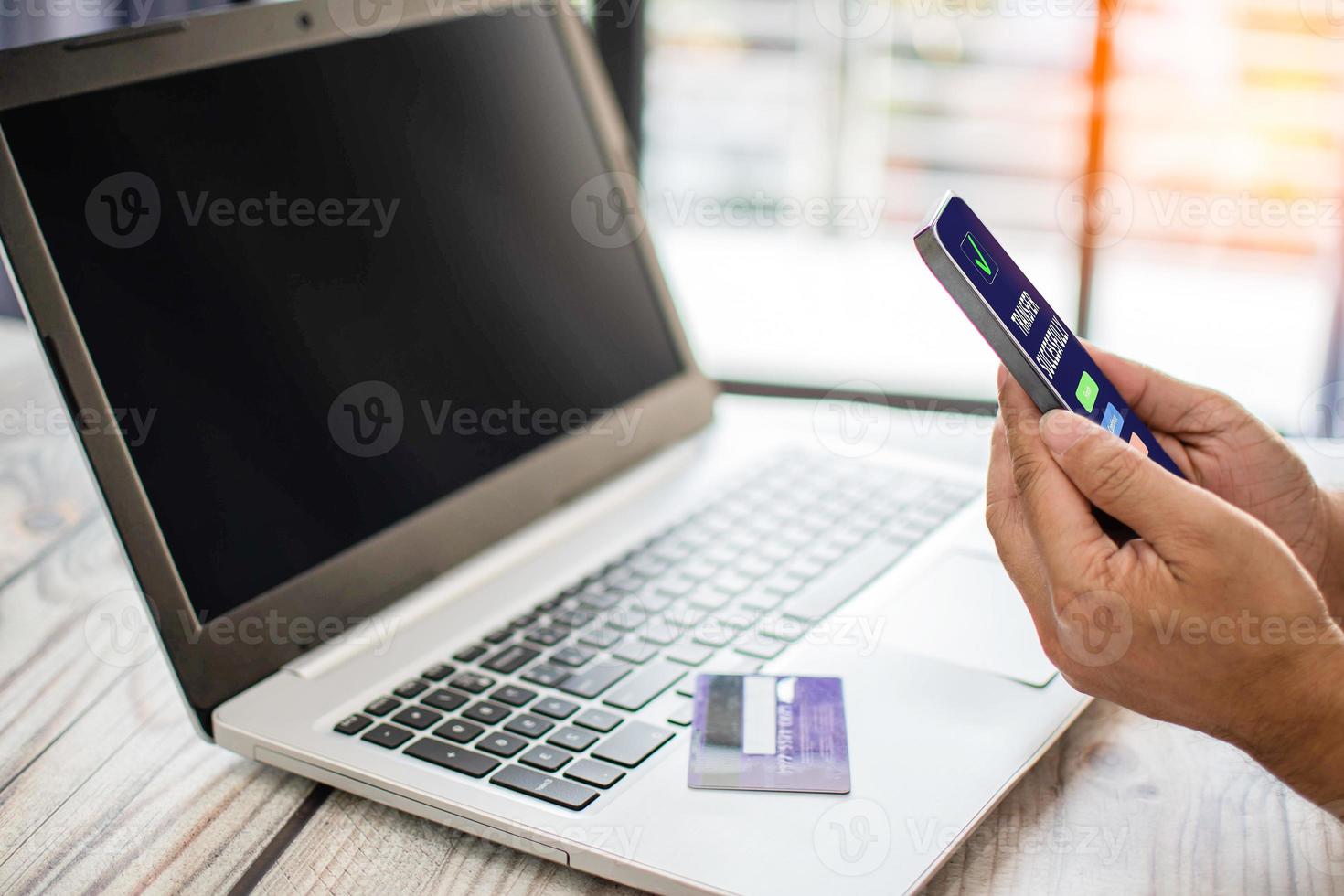 los hombres usan teléfonos inteligentes para comprar en línea. los empresarios transfieren dinero a través de Internet. la mano de un hombre sostiene un teléfono inteligente para el pago. foto