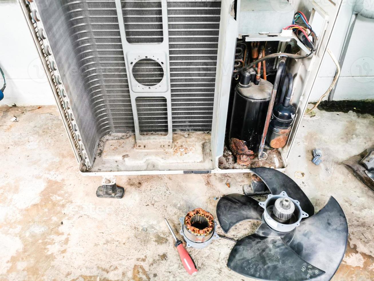 Maintenance of the air conditioner by replacing the fan motor. Mechanics use a flat screwdriver for removing the cover of the machine, and it is very easy. photo