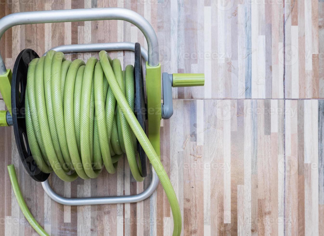 Green rubber hose in the plastic reel set. photo